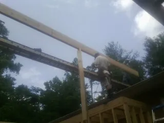 Carpenter setting a ridge beam over a new addition frame — Ice Dam Removal by Roofing Brothers in Stillman Valley