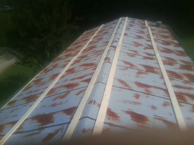 Rusted metal roof panels with new wood purlins before replacement — Storm Damage Roof Repair in Stillman Valley by Roofing Brothers