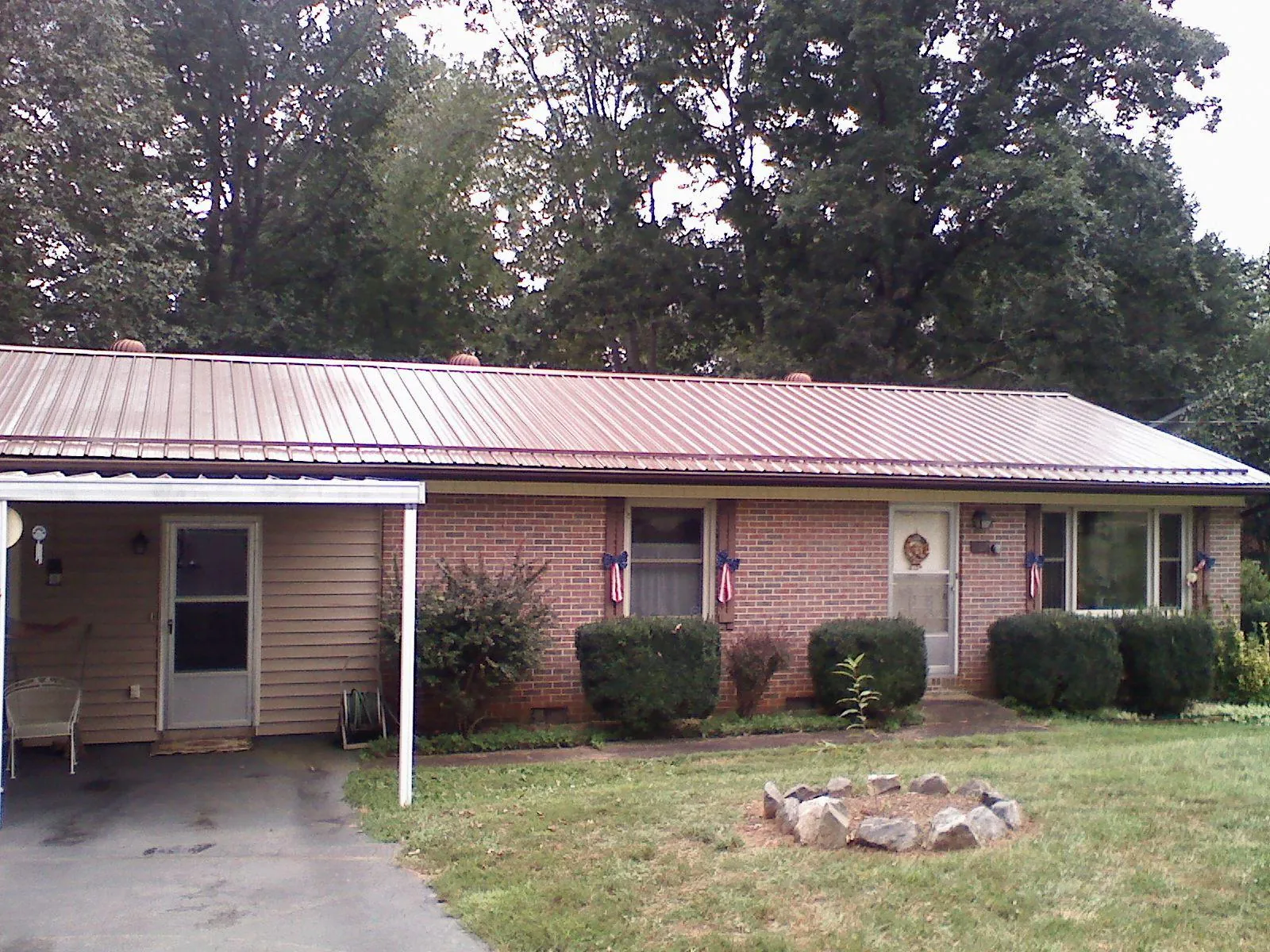 Bronze metal roof and carport on a brick ranch home — Roof Repair work by our crew in Stillman Valley