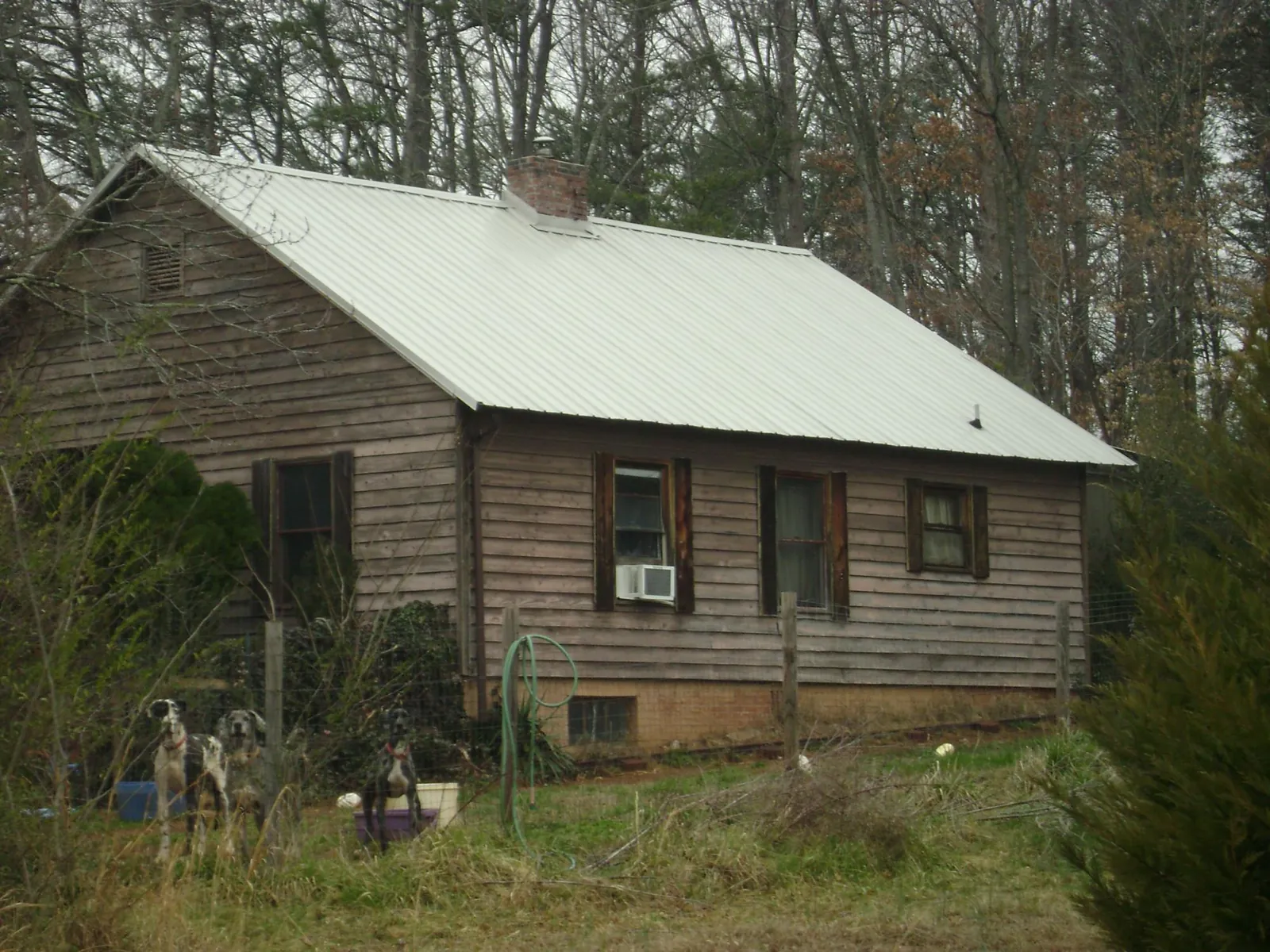 White metal roof on an old wood sided farmhouse, from a Metal Roof Installation job in Stillman Valley